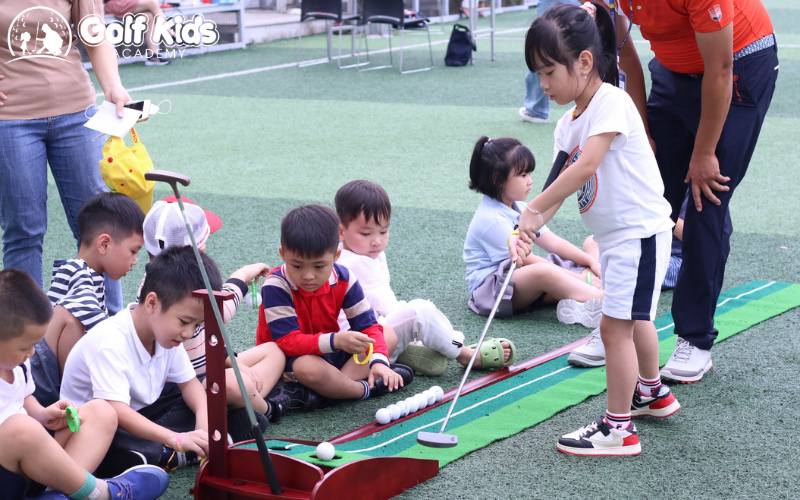 trẻ em học đánh golf