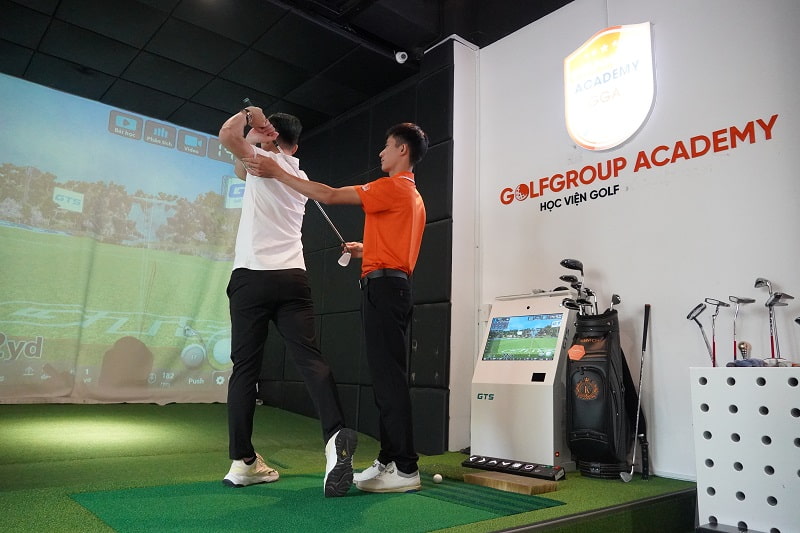 HLV Hồ Đức (áo cam) đang chỉnh kỹ thuật đánh golf cho học viên